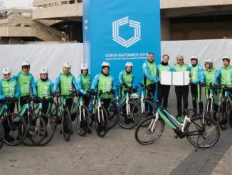 Des cyclistes en vélos électriques font la promotion du transport à faible émission de carbone à la COP24